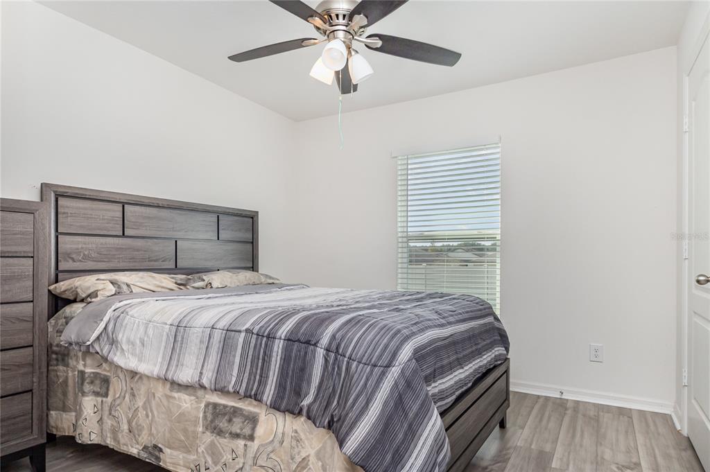 1760 Canaan Loop Dundee, FL 33838 - Photo 20 of 25 a bedroom with a bed and wooden floor