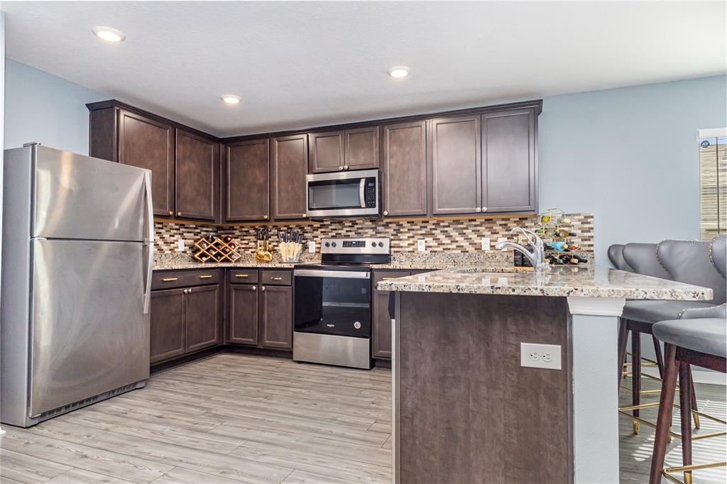 1760 Canaan Loop Dundee, FL 33838 - Photo 9 of 25 a kitchen with granite countertop a refrigerator stove top oven and sink