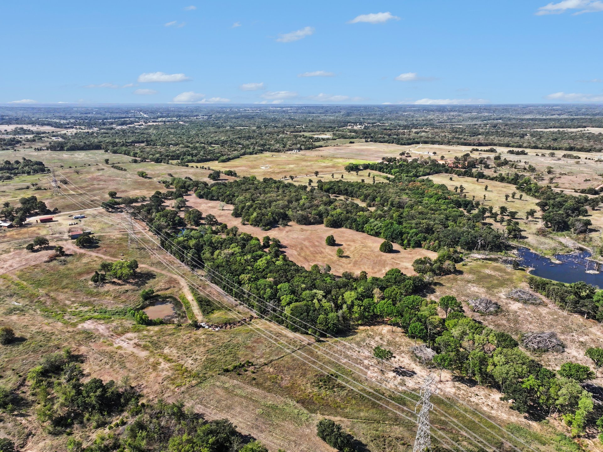 12526 3520th Road Seminole, OK 74868 - Photo 40 of 42 Expansive acreage with natural terrain, mature tree coverage, and a visible pond