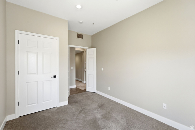 900 Bitner Road, Unit P17 Park City, UT 84098 - Photo 20 of 45 Neutral-toned room featuring a six-panel white door with black hardware, recessed ceiling lighting, and light gray wall-to-wall carpeting