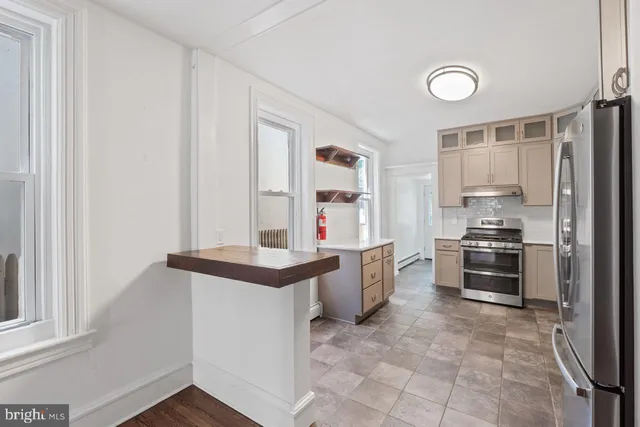 a kitchen that has a lot of cabinets in it and stainless steel appliances