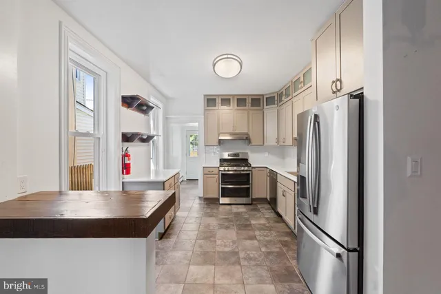 a kitchen with granite countertop a refrigerator and a stove top oven