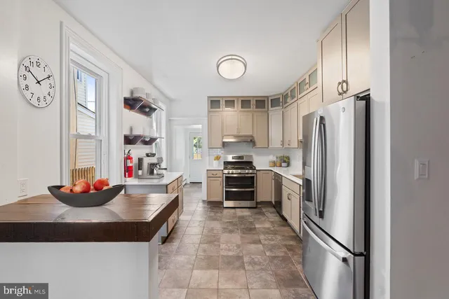 a kitchen with stainless steel appliances a refrigerator sink and cabinets
