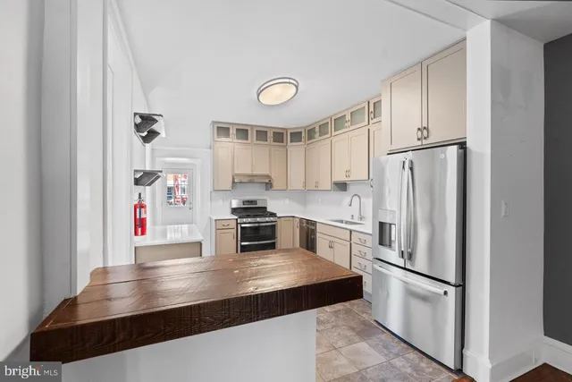 a kitchen with stainless steel appliances a refrigerator sink and cabinets