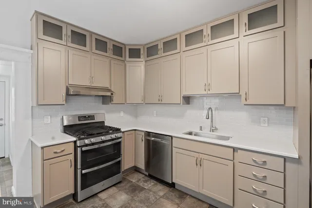 a kitchen with cabinets appliances and a sink