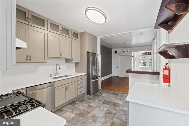 a kitchen with stainless steel appliances a stove a sink and a refrigerator
