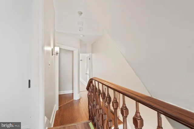 a view of staircase with railing and white walls