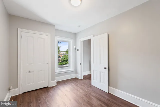 an empty room with wooden floor and window