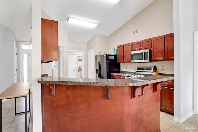a kitchen with stainless steel appliances granite countertop a stove a sink and a refrigerator