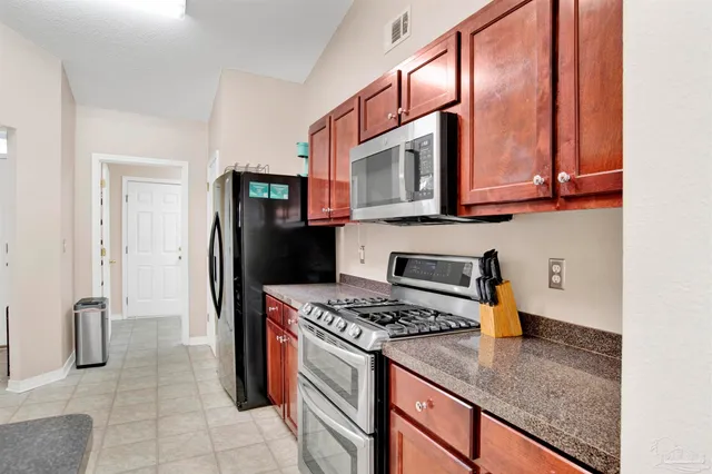 a kitchen with stainless steel appliances granite countertop a refrigerator stove and sink