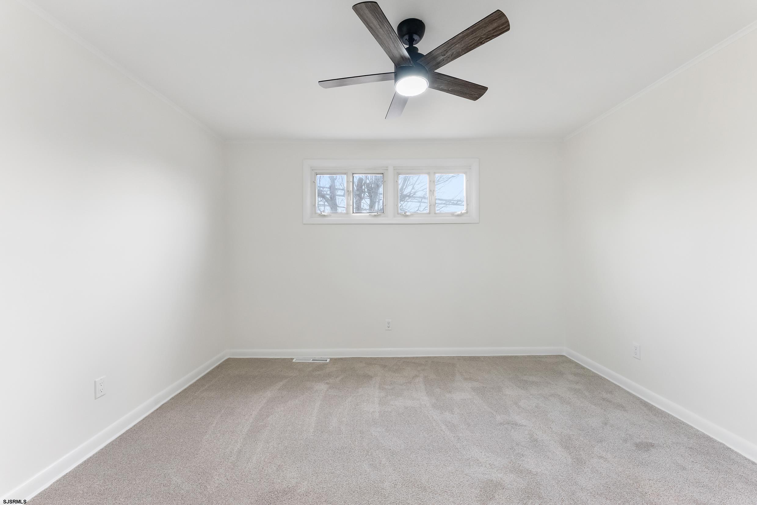 1805 Zion Road Northfield, NJ 08225 - Photo 12 of 25 an empty room with a window and a fan