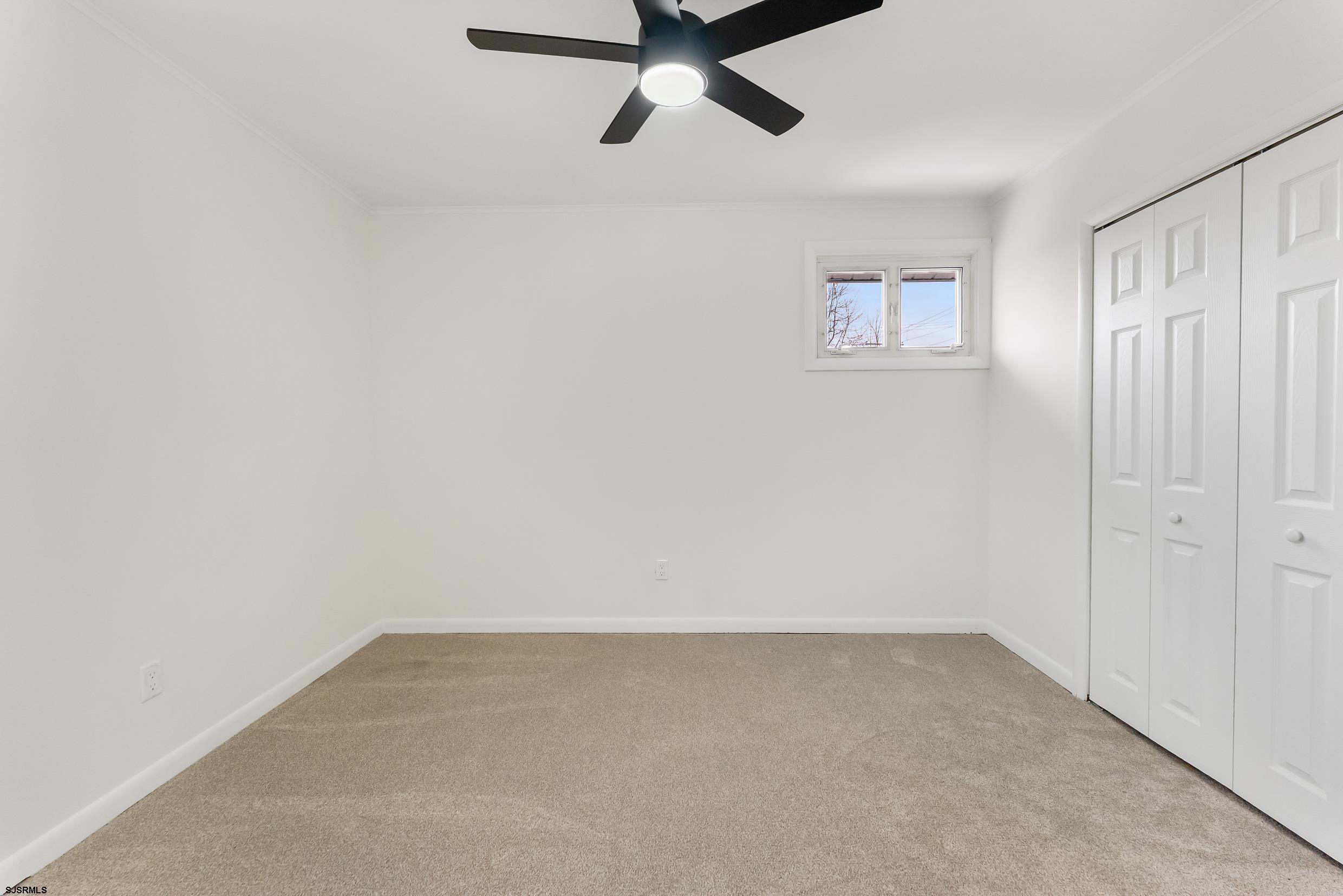 1805 Zion Road Northfield, NJ 08225 - Photo 13 of 25 an empty room with a ceiling fan and a window