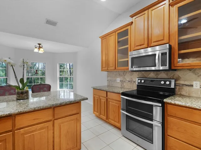 a kitchen with stainless steel appliances granite countertop a sink a refrigerator and cabinets
