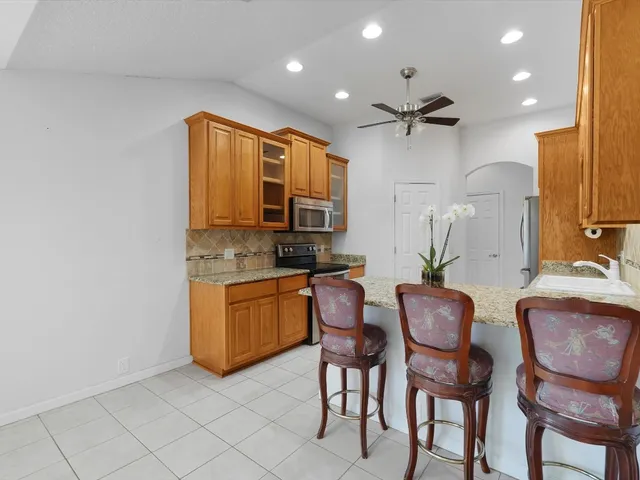 a kitchen with cabinets and chairs