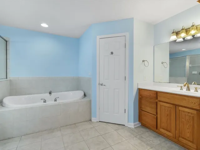 a bathroom with a tub a sink shower and mirror