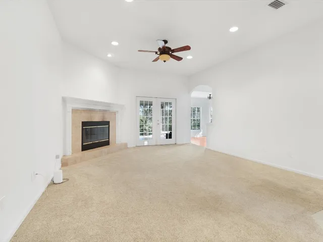 an empty room with fan and windows