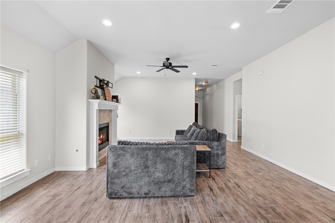 3088 Peterson Circle Bryan, TX 77802 - Photo 9 of 29 Living area featuring light wood finished floors, recessed lighting, a tile fireplace, ceiling fan, and lofted ceiling