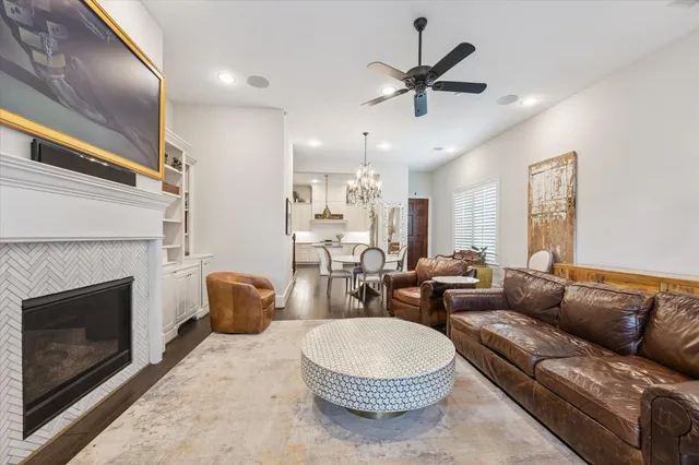 a living room with furniture a fireplace and a ceiling fan