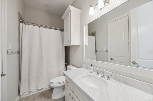 a bathroom with a sink a toilet and shower curtain