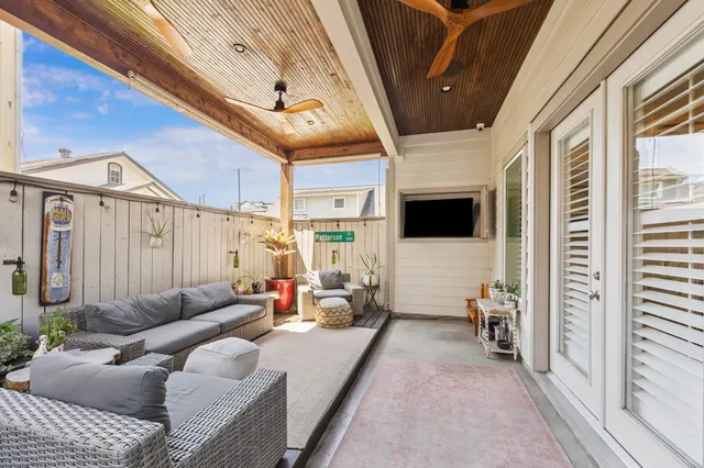a living room with furniture a flat screen tv and a floor to ceiling window