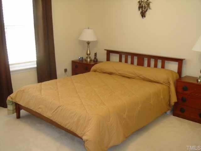 8508 Flying Buttress Drive Raleigh, NC 27613 - Photo 9 of 12 a large bed sitting in a bedroom next to a window