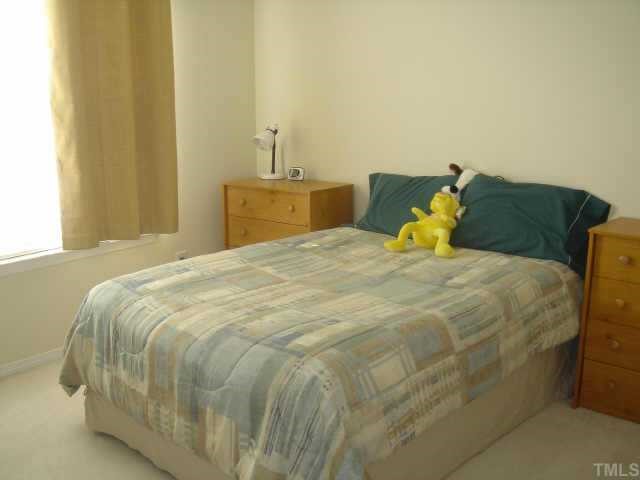 8508 Flying Buttress Drive Raleigh, NC 27613 - Photo 10 of 12 a large bed sitting in a bedroom next to a window