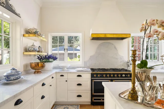 a kitchen with stainless steel appliances kitchen island granite countertop a sink and a white cabinets