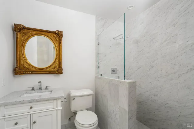 a bathroom with a toilet sink vanity and mirror