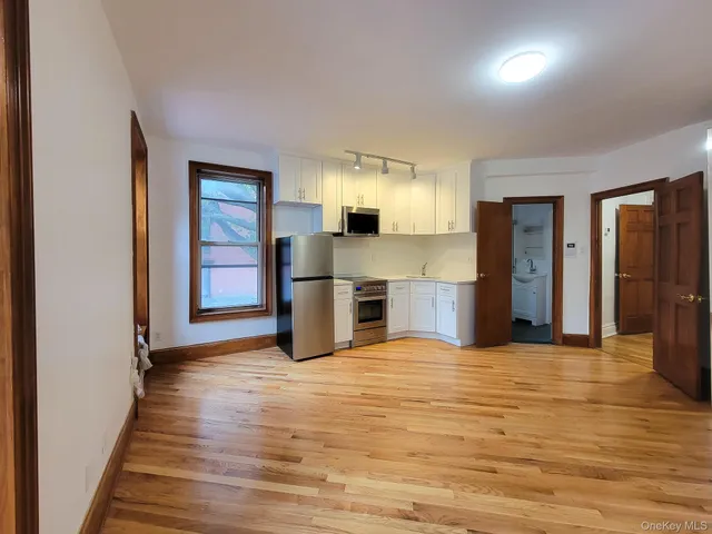 a view of a kitchen with a sink and a refrigerator