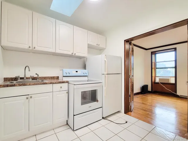 a kitchen with granite countertop white cabinets and white appliances