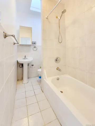 a bathroom with a bathtub a sink a toilet and shower