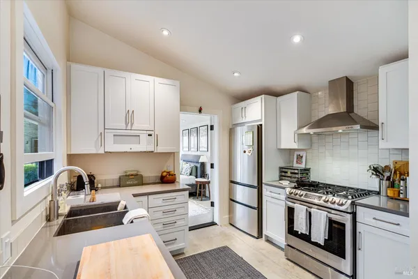 a kitchen with stainless steel appliances a stove a sink a refrigerator and cabinets