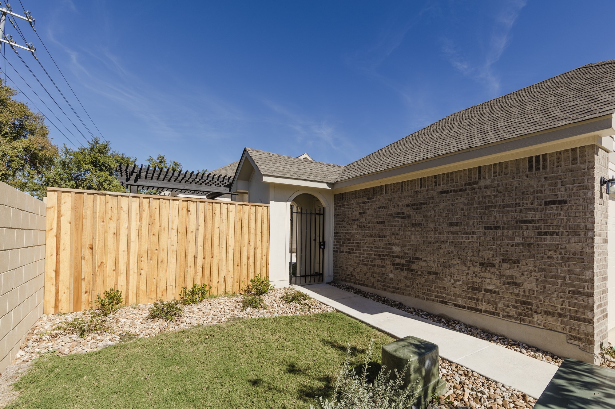 2725 Hopi Path Leander, TX 78641 - Photo 5 of 30 A well-maintained facade with brick construction and a private wooden fence.