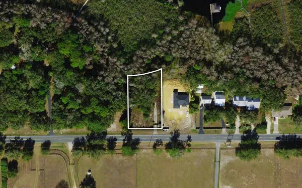 a view of swimming pool with lawn chairs and plants