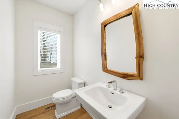 a bathroom with a toilet a sink and a mirror