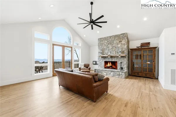 a room with stainless steel appliances kitchen island granite countertop a table chairs and a refrigerator