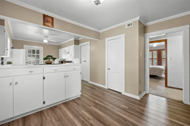 a kitchen with a sink cabinets and wooden floor
