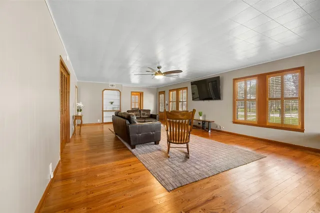 a living room with furniture a dining table and wooden floor