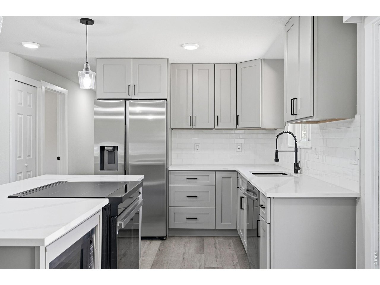 1035 6th Street Berthoud, CO 80513 - Photo 13 of 37 a kitchen with a sink a center island and cabinets