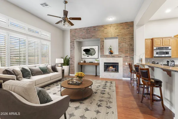 a view of an empty room with wooden floor and a fireplace