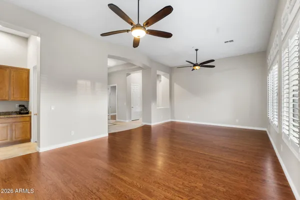 a view of an empty room with a window and wooden floor