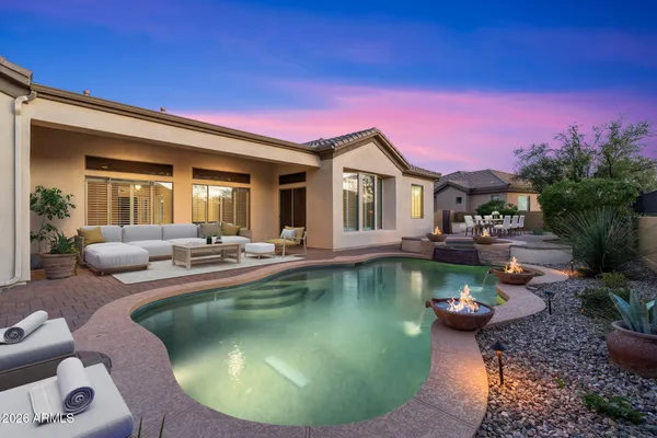 a view of a patio with couches and a table and chairs with wooden fence