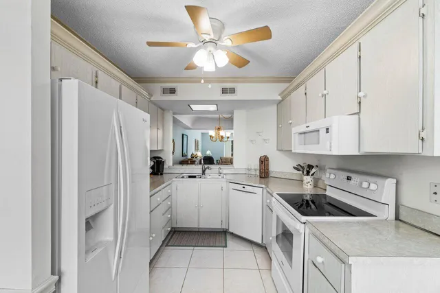 a kitchen with white cabinets and white appliances