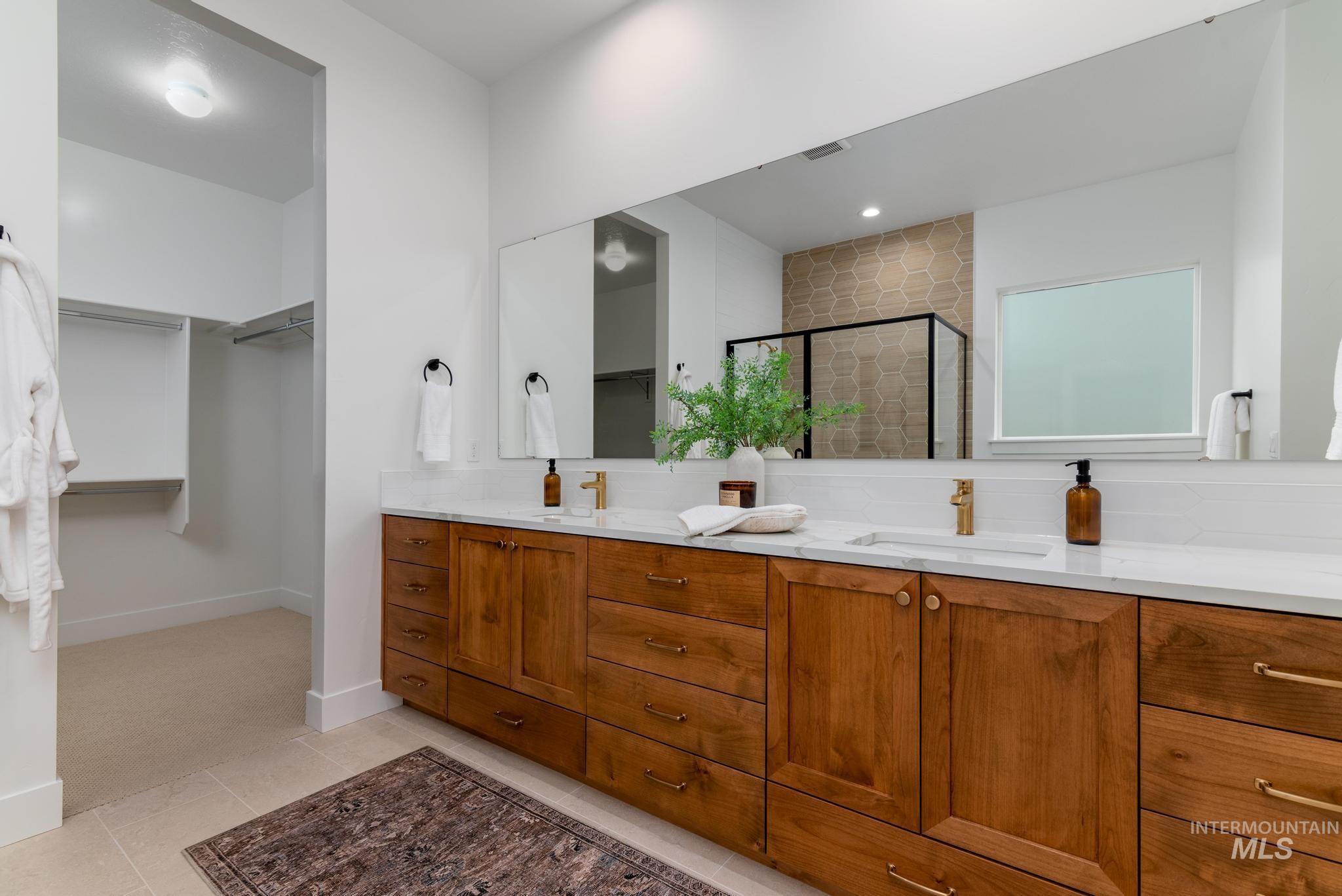 9044 West Purple Martin Street Star, ID 83669 - Photo 11 of 14 Full bath featuring a walk in closet, double vanity, a stall shower, light tile patterned floors, and tasteful backsplash