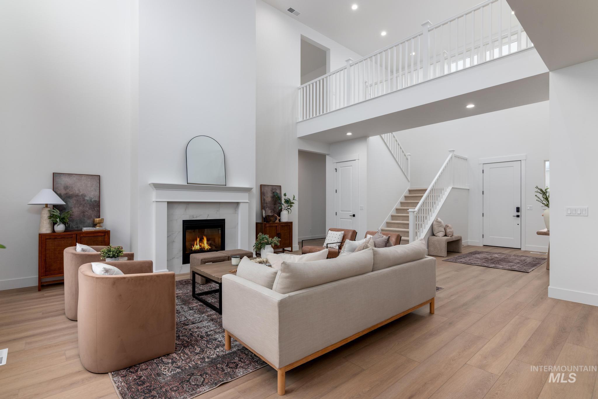9044 West Purple Martin Street Star, ID 83669 - Photo 2 of 14 Living room with light wood-type flooring, a premium fireplace, a high ceiling, and recessed lighting