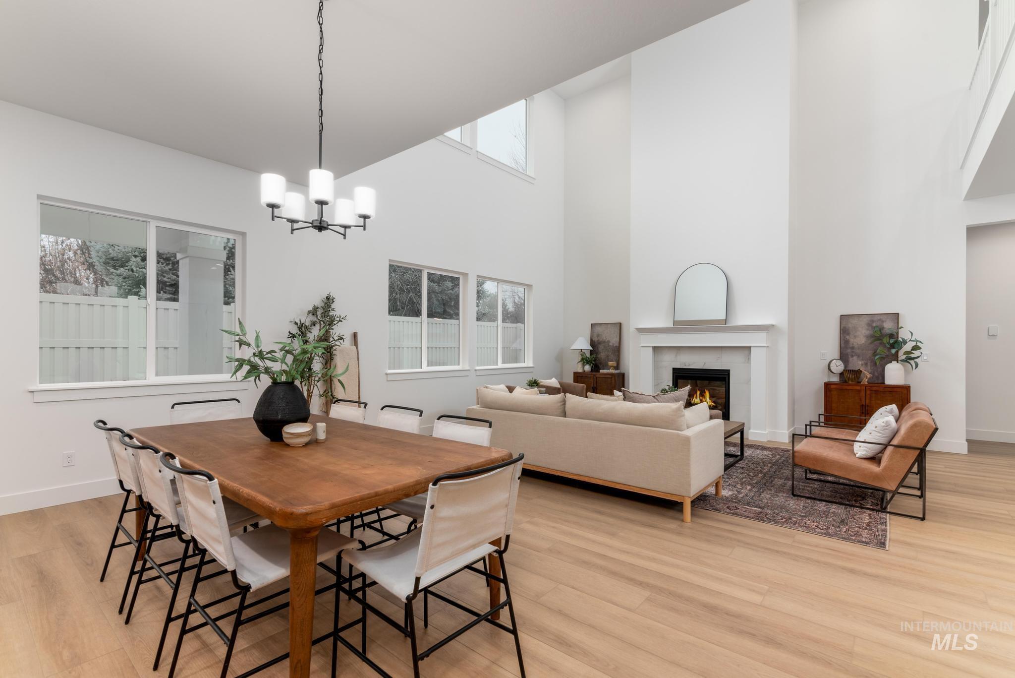 9044 West Purple Martin Street Star, ID 83669 - Photo 3 of 14 Dining space featuring a high end fireplace, light wood finished floors, a high ceiling, and a chandelier