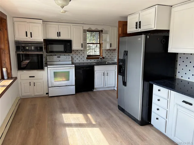a kitchen with granite countertop a refrigerator stove and oven