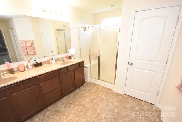 a bathroom with a double vanity sink a mirror and a shower