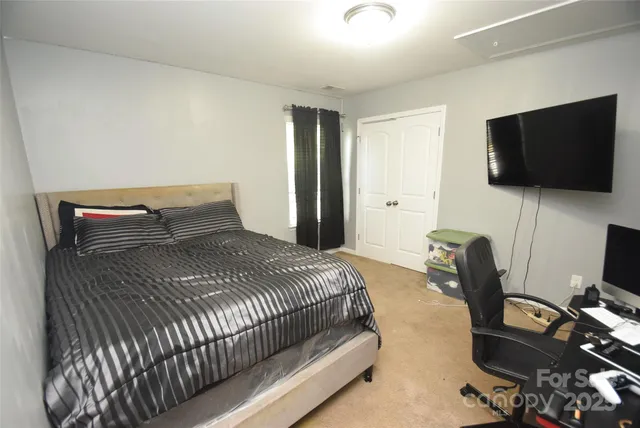 a bedroom with a bed and a flat screen tv