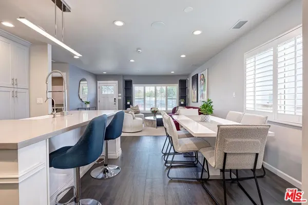a large white kitchen with dining table and chairs